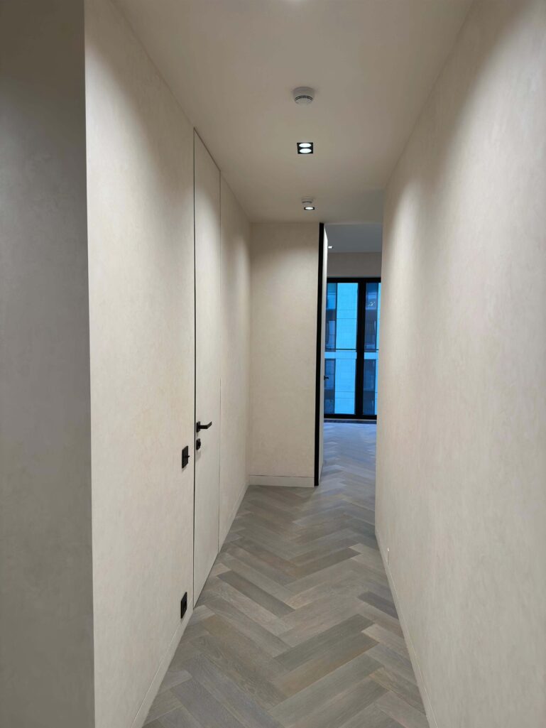 Декоративная штукатурка мокрый шелк Italica Luce в интерьере со скрытыми дверьми